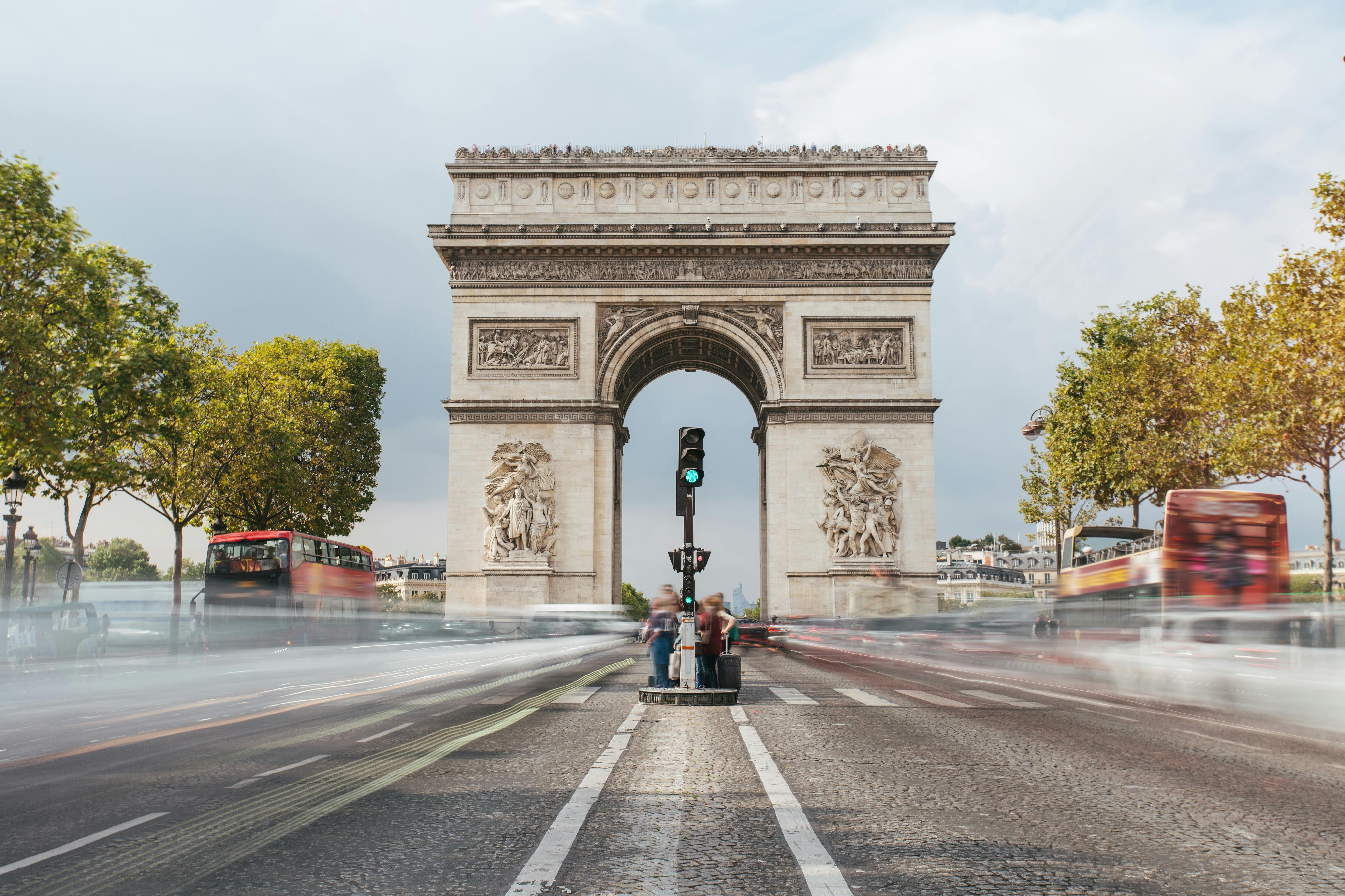 Long-exposure photograph of the Arc de Triomphe in daylight.